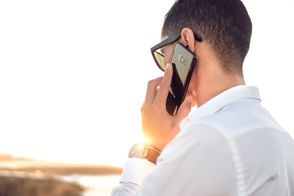 Man wearing white talking on phone
