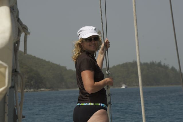 moving to the sunshine coast - Kath wearing black swimsuit and white cap and sunglasses while sailing through the Whitsunday Islands