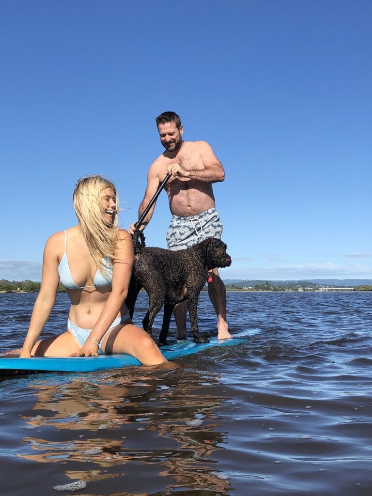 Byron Jasmine and their dog on a Paddle Board