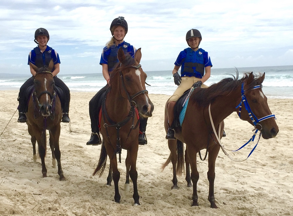 Three kids wearing blue polo while horsing around at Noosa Northshore
