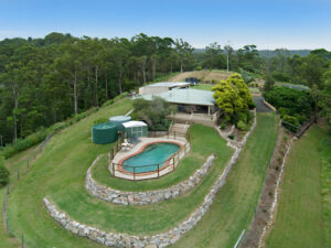 Bird's-eye view of a home with a pool and surrounding trees, capturing the essence of the Sunshine Coast landscape.