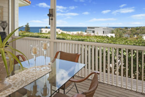 Balcony furniture featuring a table and chairs, offering a picturesque ocean view in Sunshine Coast area