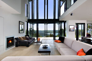A luminous living room featuring a cozy couch, elegant coffee table, and a warm fireplace, captured by Byron Miller in the scenic Sunshine Coast.