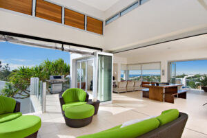 A photo of the living room in the residence of Sunshine Coast, adorned with green chairs and simple interior design.