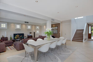 A photo of a dining room featuring a table surrounded by beautiful white chairs.