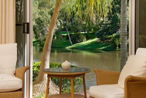 A contemporary apartment complex with palm trees in the foreground, emphasizing a stylish urban living environment.