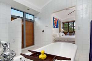 A ensuite bathroom with a bathtub facing the bedroom on the Sunshine Coast.
