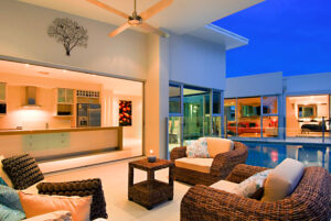 A photo of a bright living room captured by Byron Miller, featuring a pool and mini-kitchen
