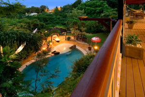 A scenic view of a pool and deck from the balcony in the area of Sunshine Coast, showcasing vibrant surroundings.