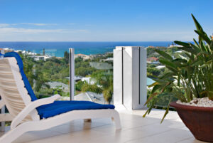 A white chair sits on the balcony, providing a peaceful spot to enjoy the sunny views of the Sunshine Coast